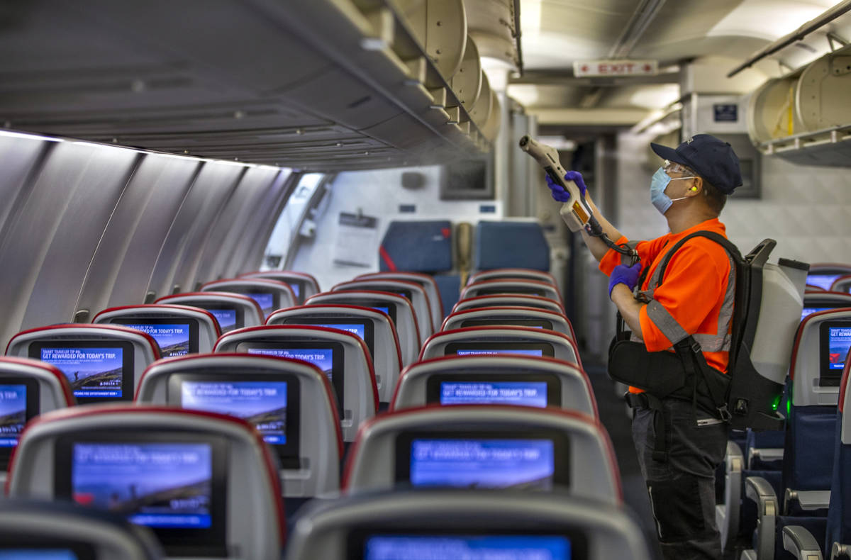 Delta Airlines employee Wansik Kim disinfects the interior of another airplane before departure ...