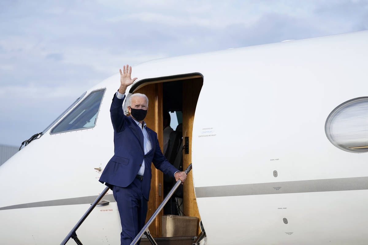 Democratic presidential candidate former Vice President Joe Biden waves as he boards a plane at ...