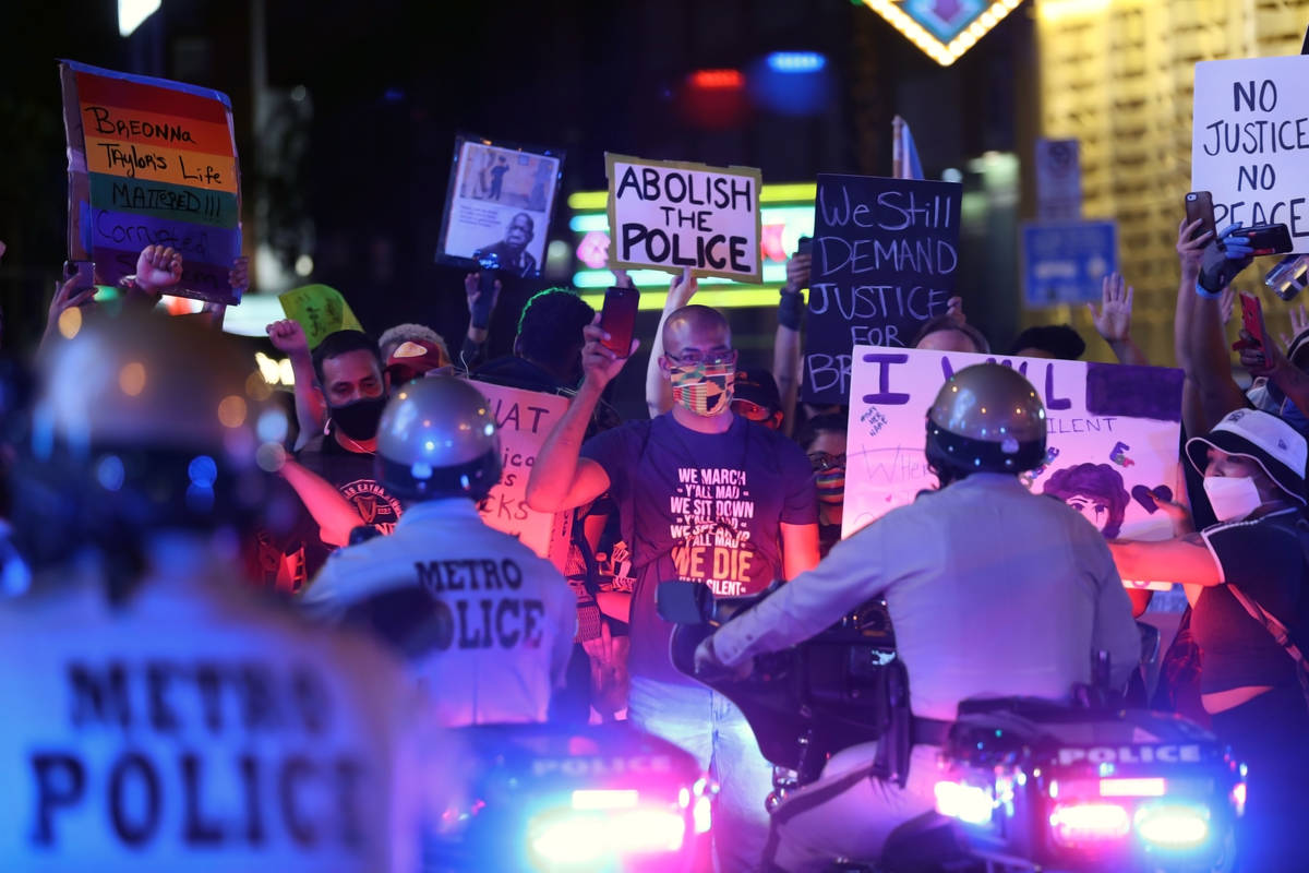 Attorney Jonathan MacArthur holds up his cellphone while facing police in downtown Las Vegas on ...