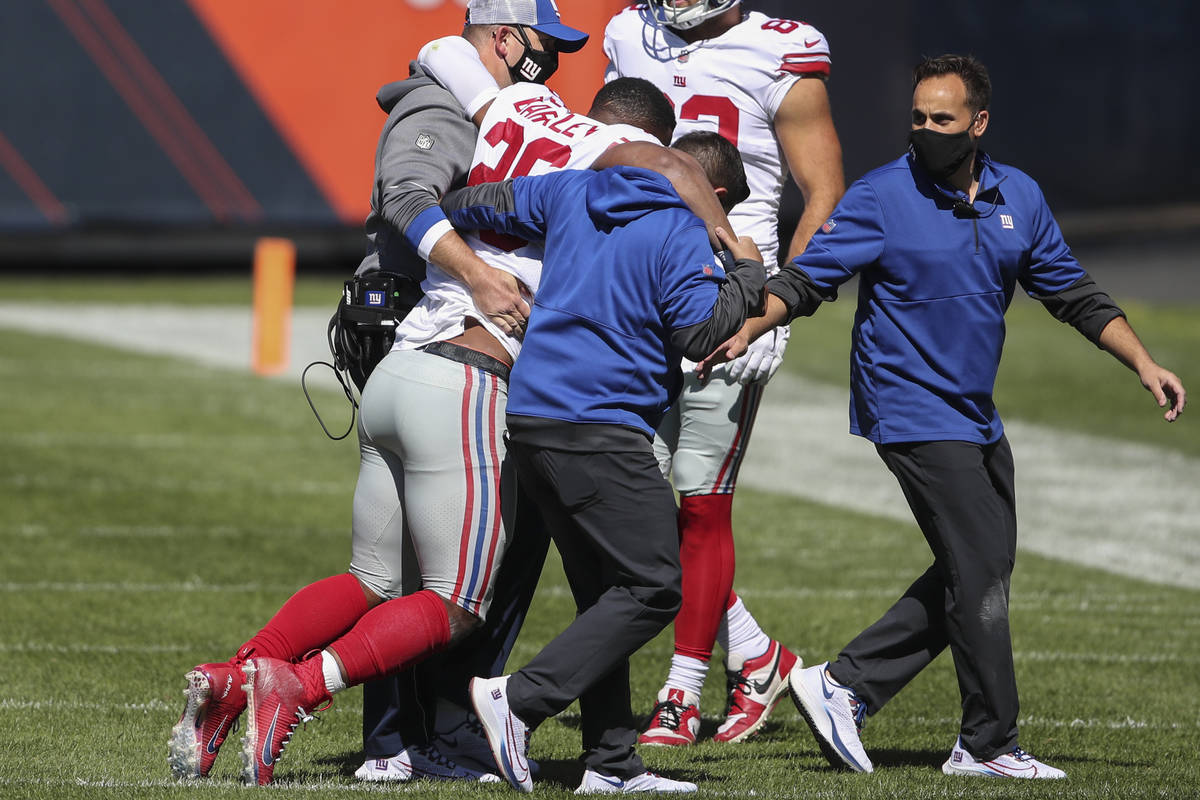 New York Giants running back Saquon Barkley is helped off the field after being injured against ...