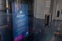 A sign stating Planet HollywoodÕs temporary closure is seen inside the doors of the hotel- ...