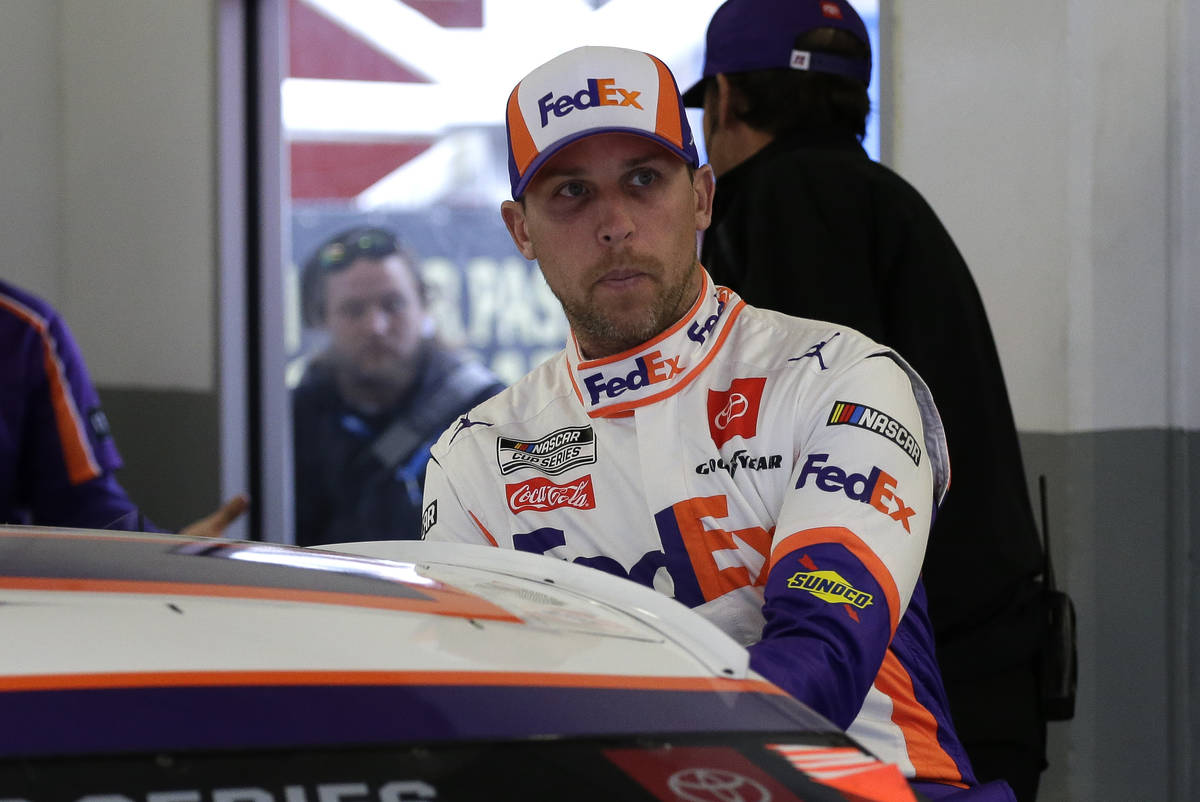 FILE - In this Feb. 14, 2020, file photo, Denny Hamlin climbs into his car as he gets ready to ...