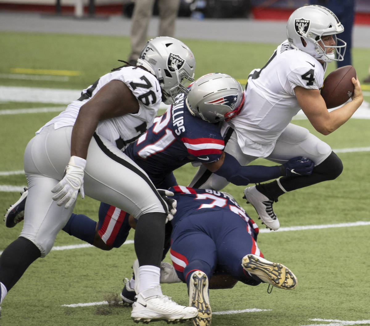 Las Vegas Raiders quarterback Derek Carr (4) is tackled for a loss by New England Patriots defe ...