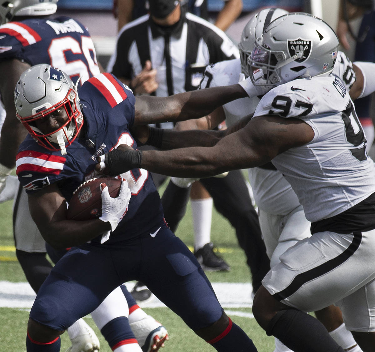 New England Patriots running back Sony Michel (26) tries to break free from Las Vegas Raiders d ...