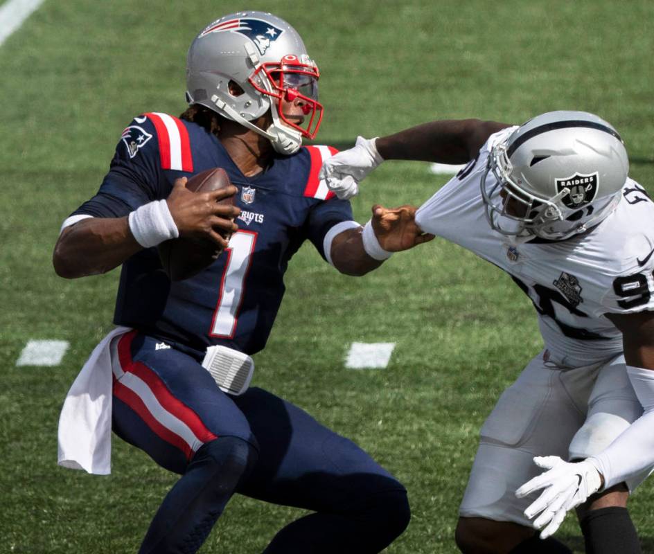 New England Patriots quarterback Cam Newton (1) stiff arms Las Vegas Raiders defensive end Clel ...