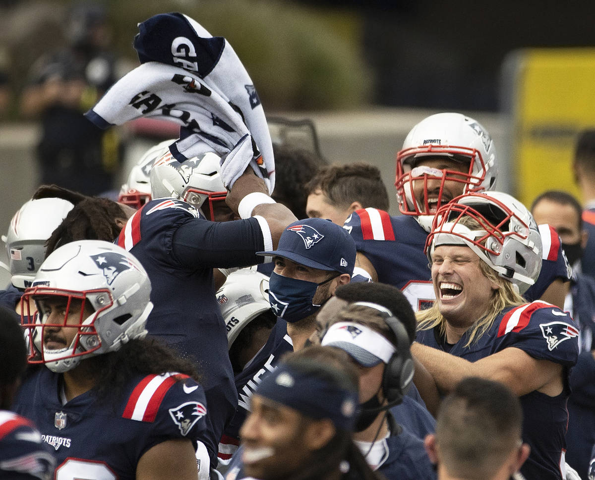 New England Patriot players celebrate a big defensive play in the fourth quarter of an NFL foo ...