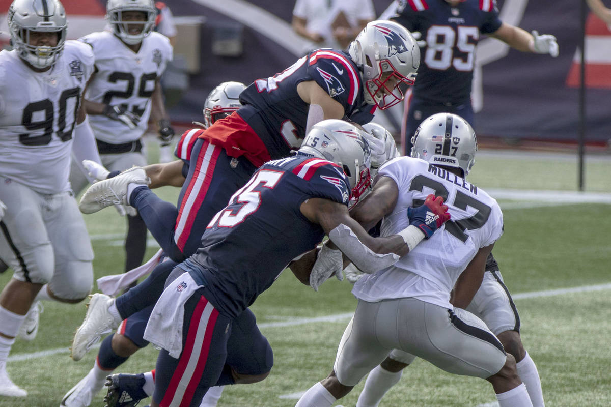New England Patriots running back Rex Burkhead (34) leaps over Las Vegas Raiders cornerback Tra ...