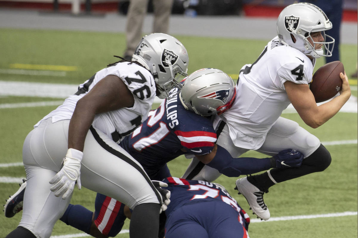 Las Vegas Raiders quarterback Derek Carr (4) is tackled for a loss by New England Patriots defe ...