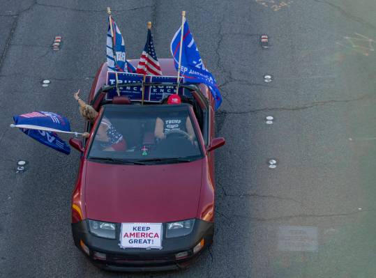 A car taking part in a caravan of Trump supporters, rides down the Las Vegas Strip, on Wednesda ...