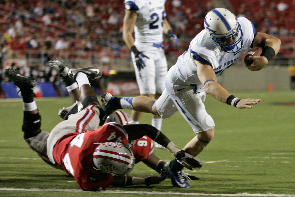 Air Force quarterback Connor Dietz (11) dives past UNLV defenders Kenny Keys (44) and Mark Garr ...