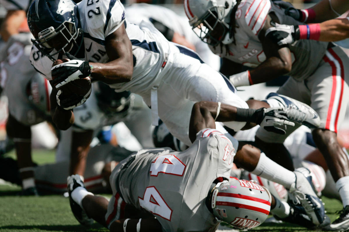 UNR running back Stefphon Jefferson (25) dives over UNLV defensive back Kenny Keys (44) for a 1 ...