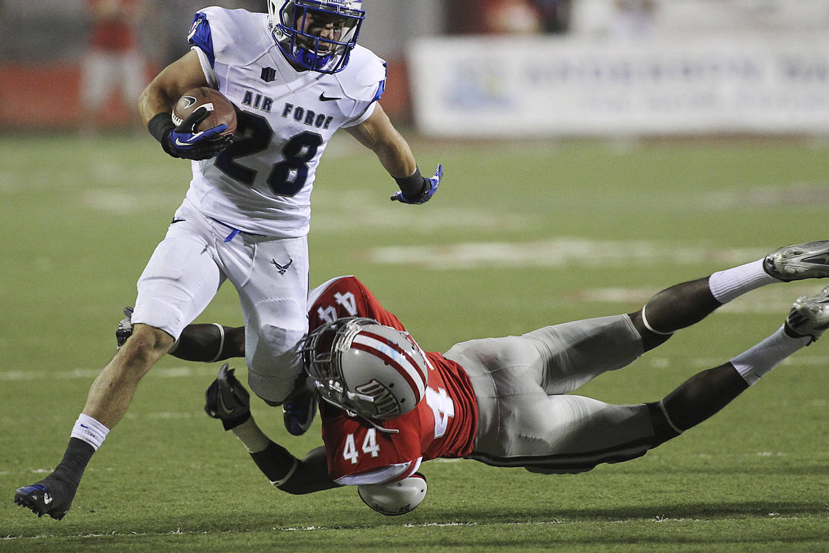 UNLV 's Kenny Keys (44) trips up Air Force Academy's Cody Getz (28) during the first half of fo ...