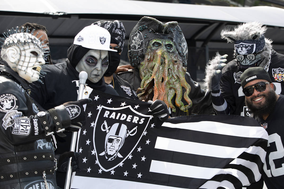 Patrick Beckett of New Jersey poses for a photo with Raiders fans in costumes as fans congregat ...