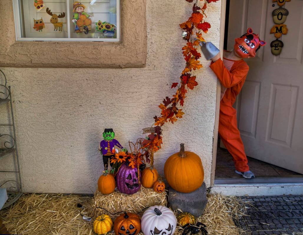 Alex Montenegro, 8, shows off his costume with the family home decorated for Halloween on Wedne ...