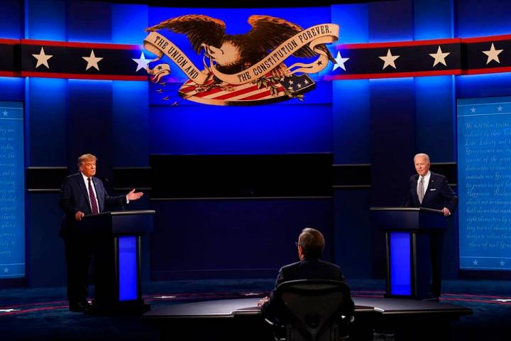 Moderator Chris Wallace of Fox News listens as President Donald Trump and Democratic candidate ...