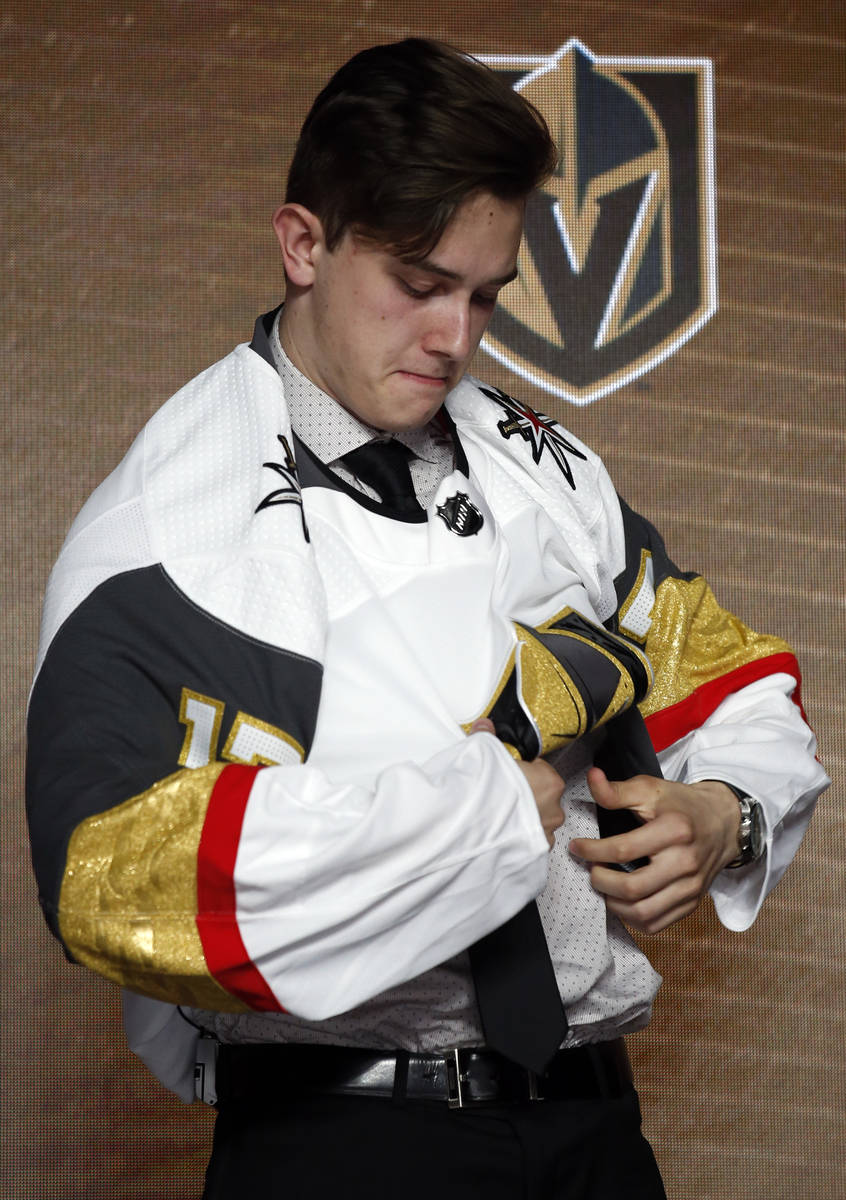 Cody Glass puts on a Vegas Golden Knights jersey after being selected by the team in the first ...