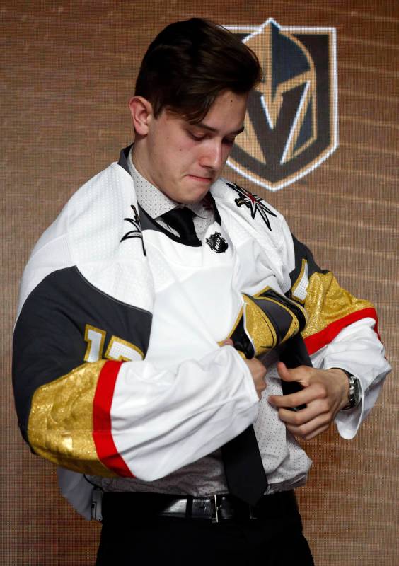 Cody Glass puts on a Vegas Golden Knights jersey after being selected by the team in the first ...