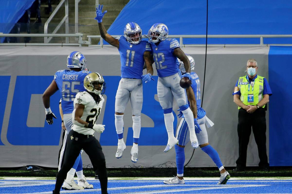 Detroit Lions running back D'Andre Swift (32) celebrates his 7-yard pass for a touchdown with t ...
