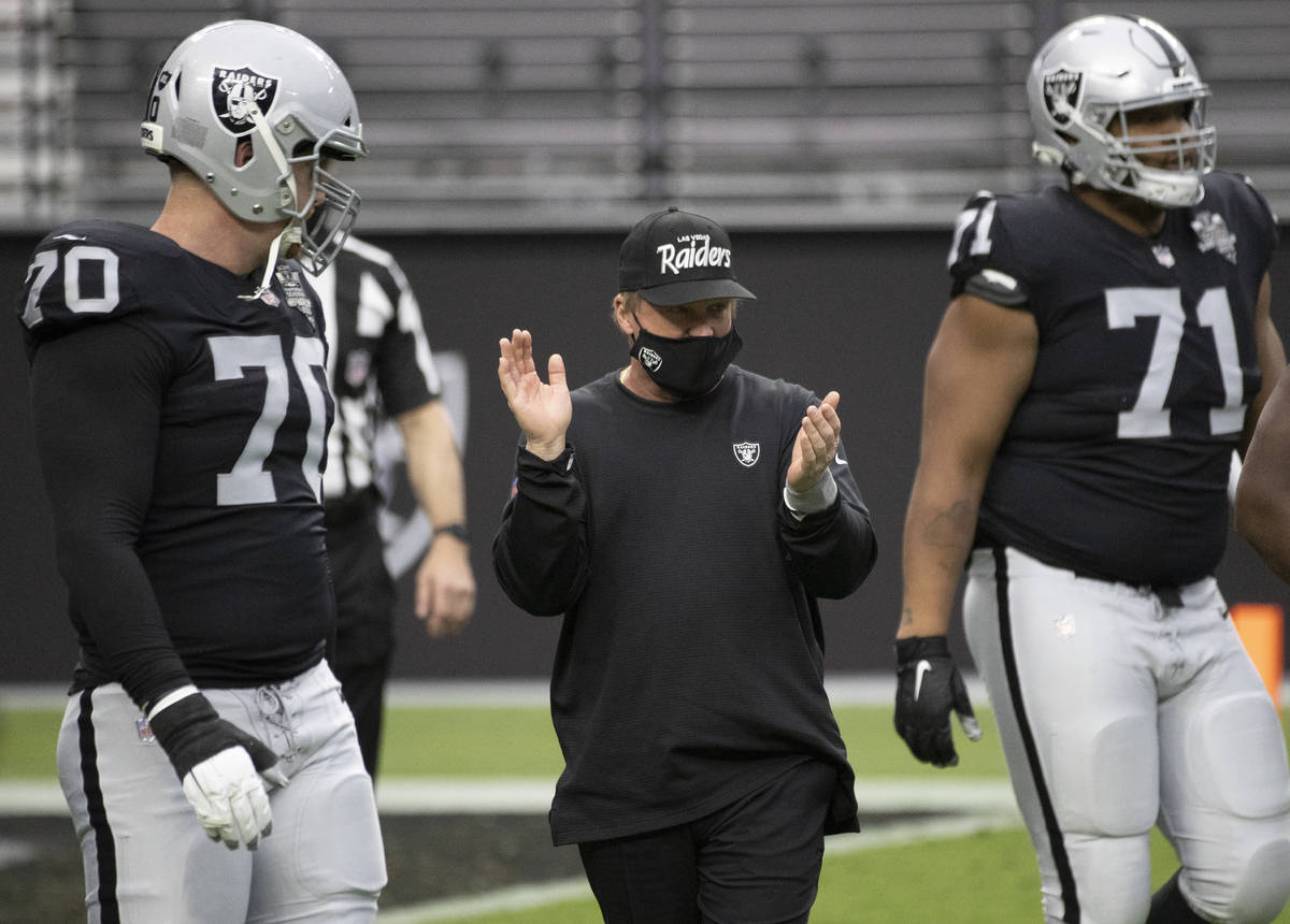 Las Vegas Raiders head coach Jon Gruden, middle, pumps up his team during warms up before the s ...