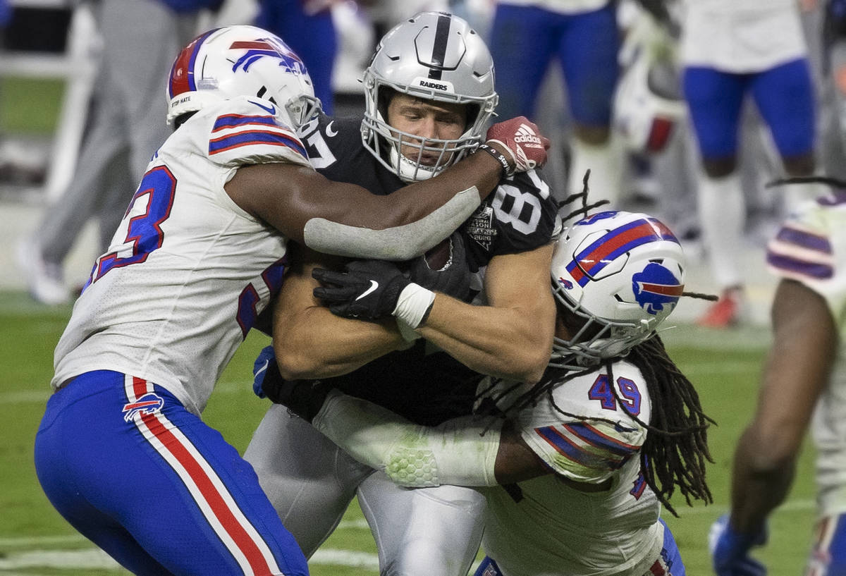 Las Vegas Raiders tight end Foster Moreau (87) fights for extra yardage with Buffalo Bills line ...