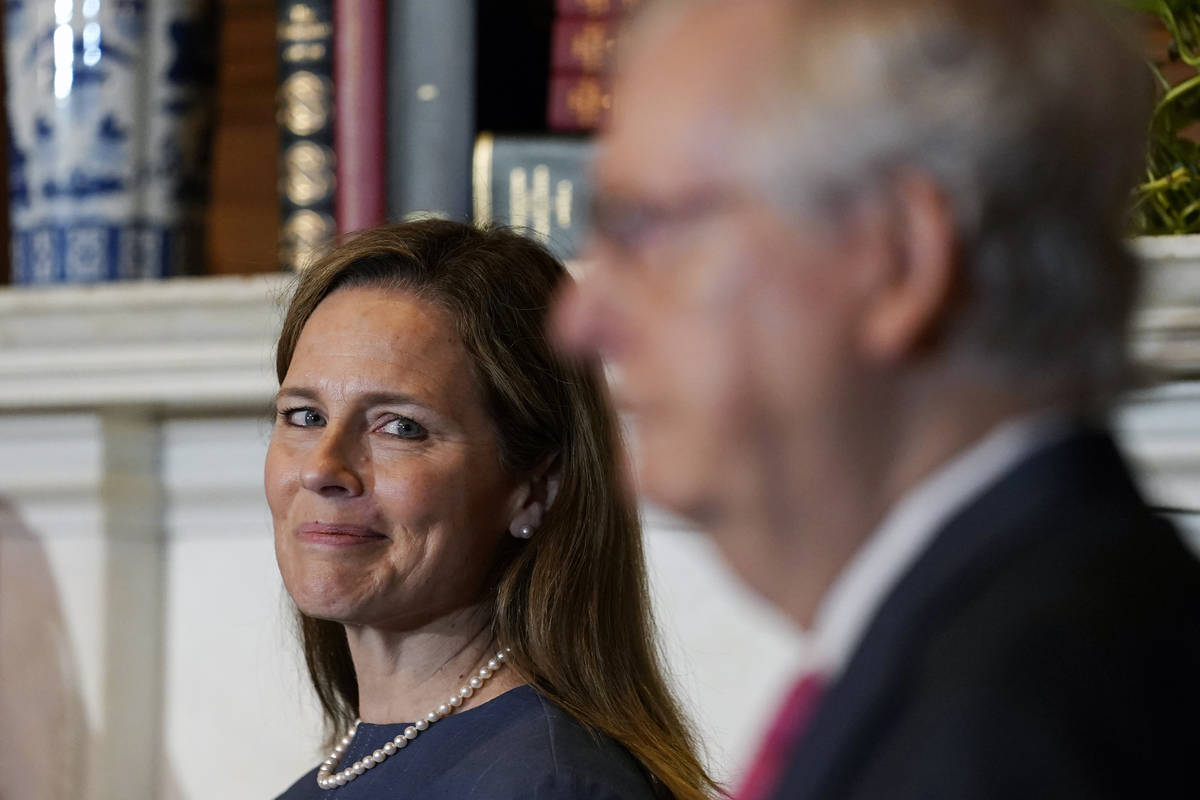 Supreme Court nominee Judge Amy Coney Barrett looks over to Senate Majority Leader Mitch McConn ...