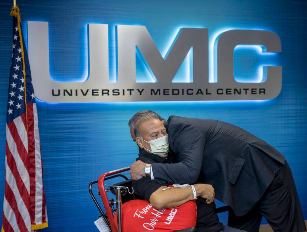 Pablo Bernabe, left, hugs University Medical Center CEO Mason Van Houweling, right, during a pr ...