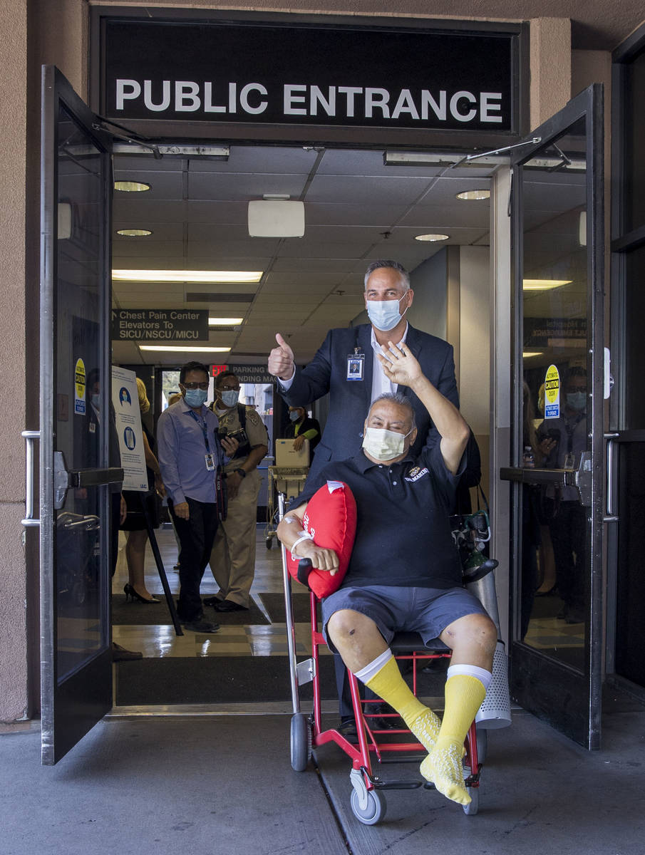 University Medical Center CEO Mason Van Houweling, above, pushes Pablo Bernabe, center, as they ...