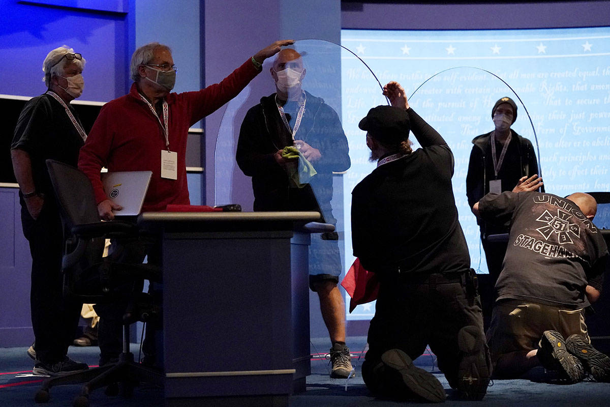 Members of the production crew inspect glass on stage which will serve as a barrier to protect ...