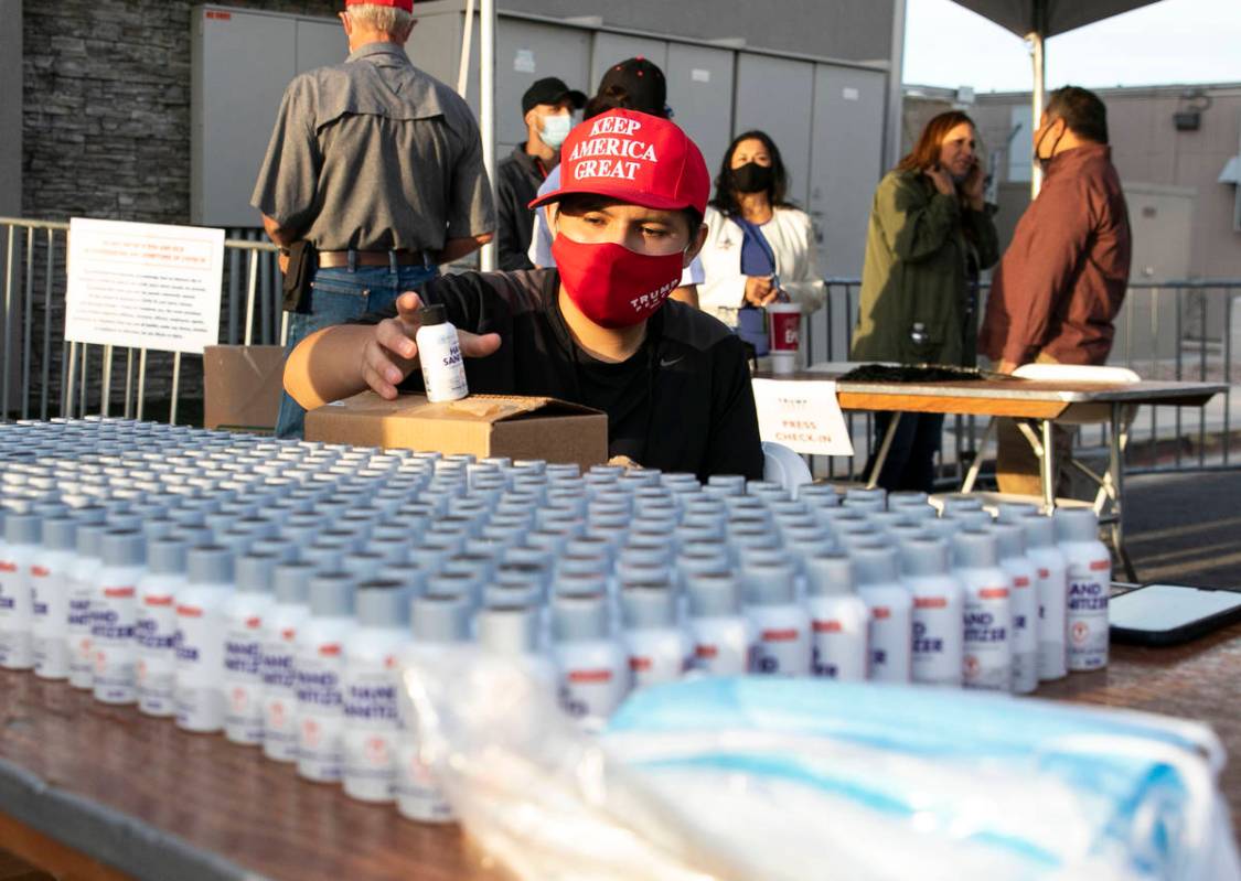 Make America Great Again event volunteer Gilbert Morales displays hand sanitizers at Boulder Ci ...