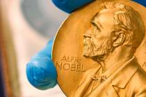 In this April 17, 2015 file photo, a national library employee shows a gold Nobel Prize medal i ...