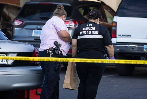 North Las Vegas police crime investigators collect evidence from an apartment where a man was f ...