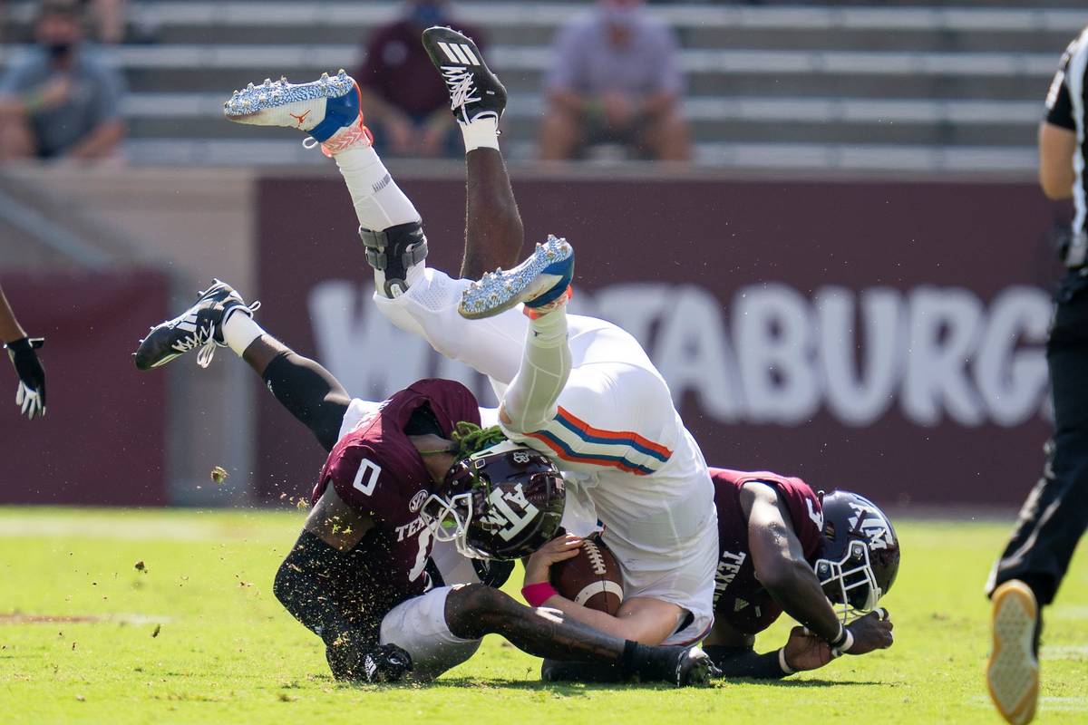 Florida quarterback Kyle Trask (11) is tackled after a short gain by Texas A&M defensive linema ...