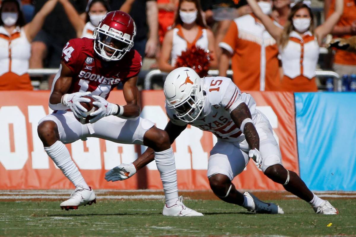 Oklahoma wide receiver Charleston Rambo (14) catches a pass in front of Texas defensive back Ch ...