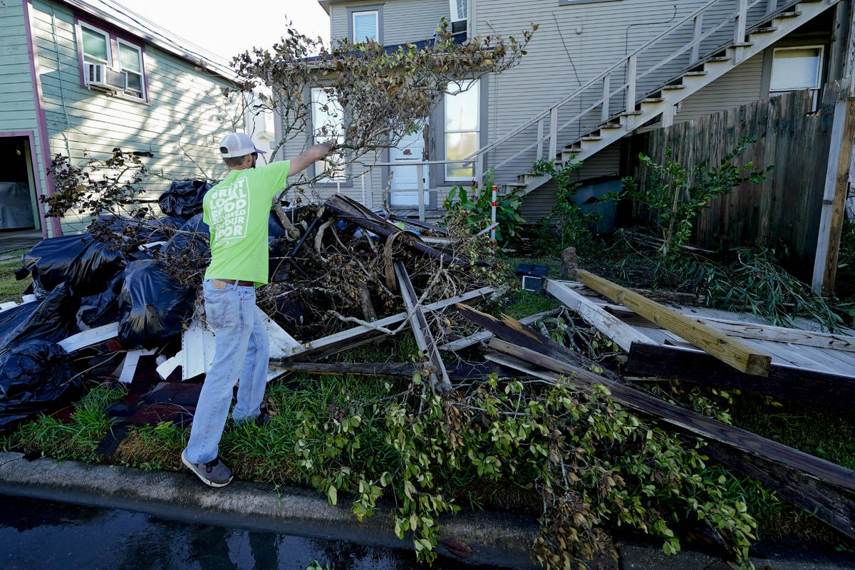 Caleb Cormier moves debris after Hurricane Delta moved through, Saturday, Oct. 10, 2020, in Lak ...