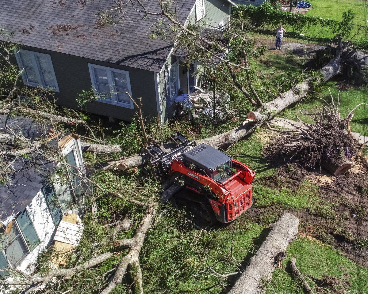 Trees are cleared that have fallen on houses during Hurricane Delta in Jennings, La., Saturday, ...