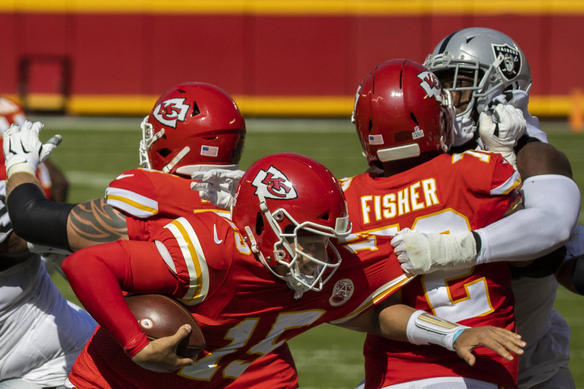 Kansas City Chiefs quarterback Patrick Mahomes (15) tries to scramble away from Las Vegas Raide ...