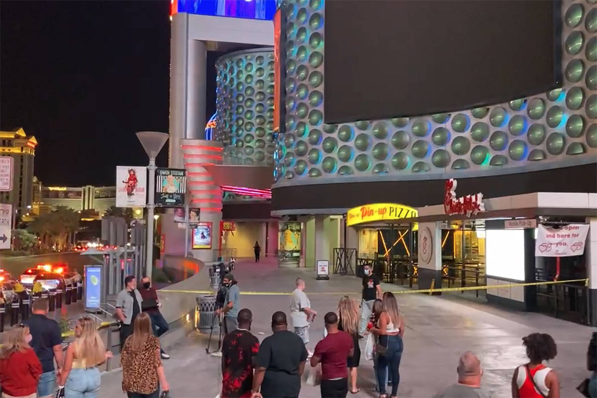 People gather at the scene of a shooting outside the Miracle Mile Shops on the Las Vegas Strip ...