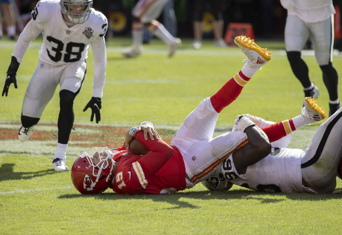 Kansas City Chiefs quarterback Patrick Mahomes (15) is tackled by Las Vegas Raiders defensive e ...