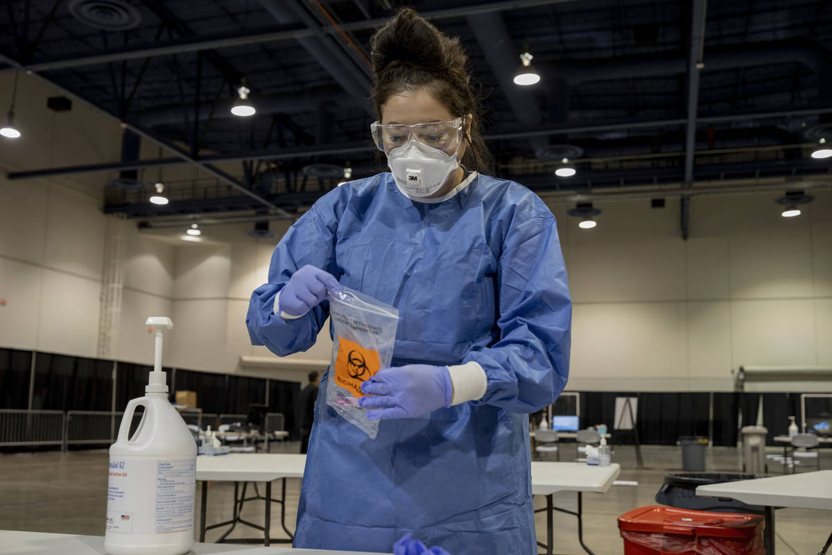 UMC respiratory therapist Diana Vega seals a COVID-19 test in a biohazard bag during a preview ...