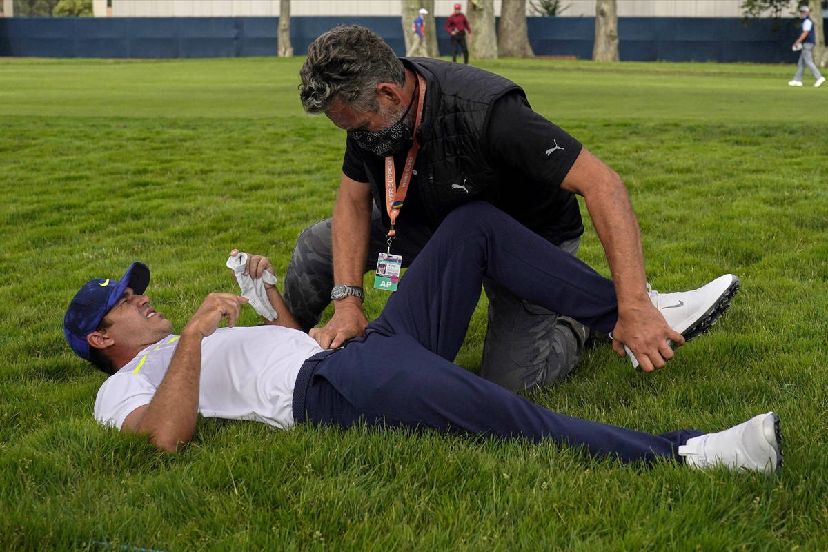 This Aug. 7, 2020, file photo shows Brooks Koepka getting treated for an injury on the 12th hol ...