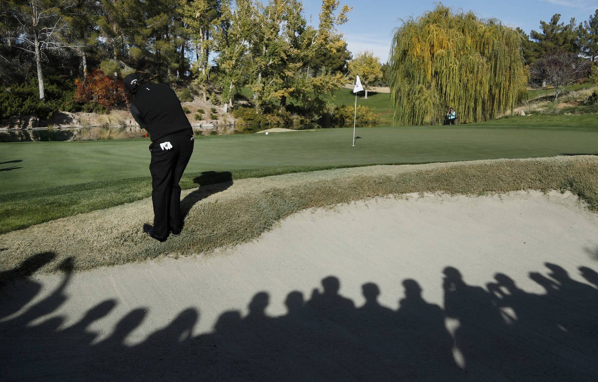 Phil Mickelson hits onto the fourth green during a golf match against Tiger Woods at Shadow Cre ...