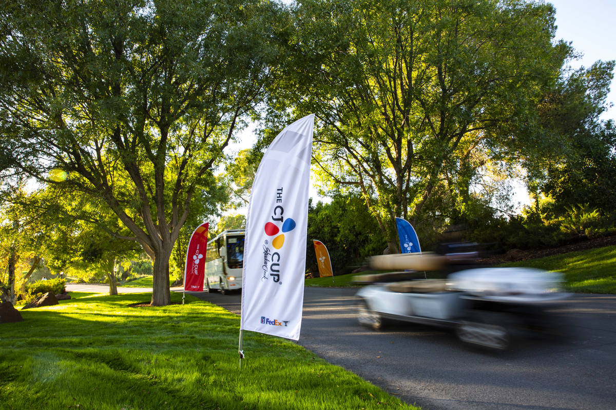 A golf cart and shuttle pass by signage for the CJ Cup at the Shadow Creek Golf Course in North ...