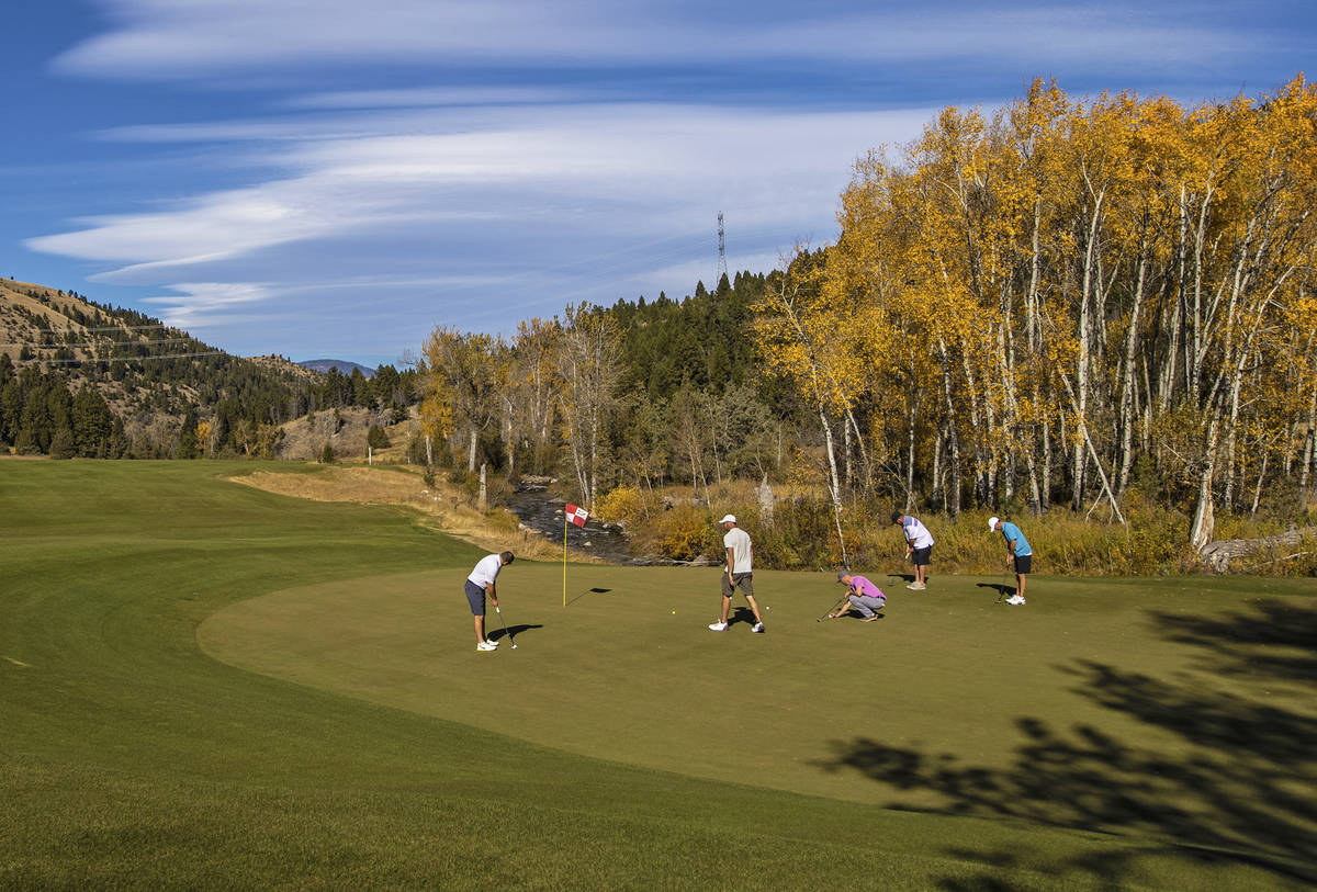 Players finish their round at the 18th hole of Rock Creek Cattle Company golf course on Friday, ...