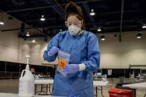 UMC respiratory therapist Diana Vega seals a COVID-19 test in a biohazard bag during a preview ...