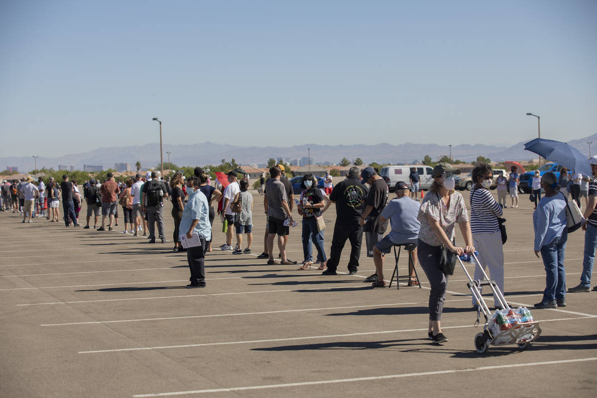 Individuals stand in line to early vote at the event tent located at Downtown Summerlin Las Veg ...