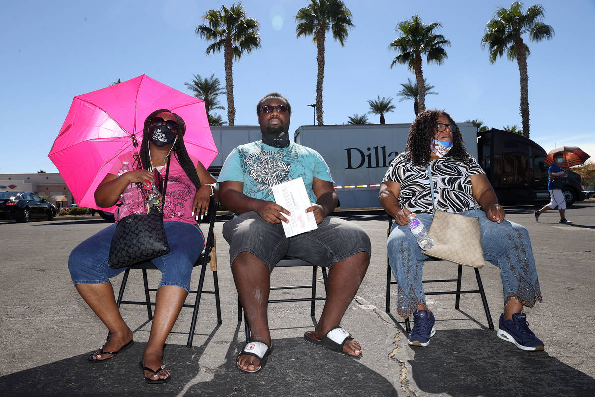 Jamailla Parks-El, from left, her son Daquan Smith and her mother Deborah Elaster, wait in line ...