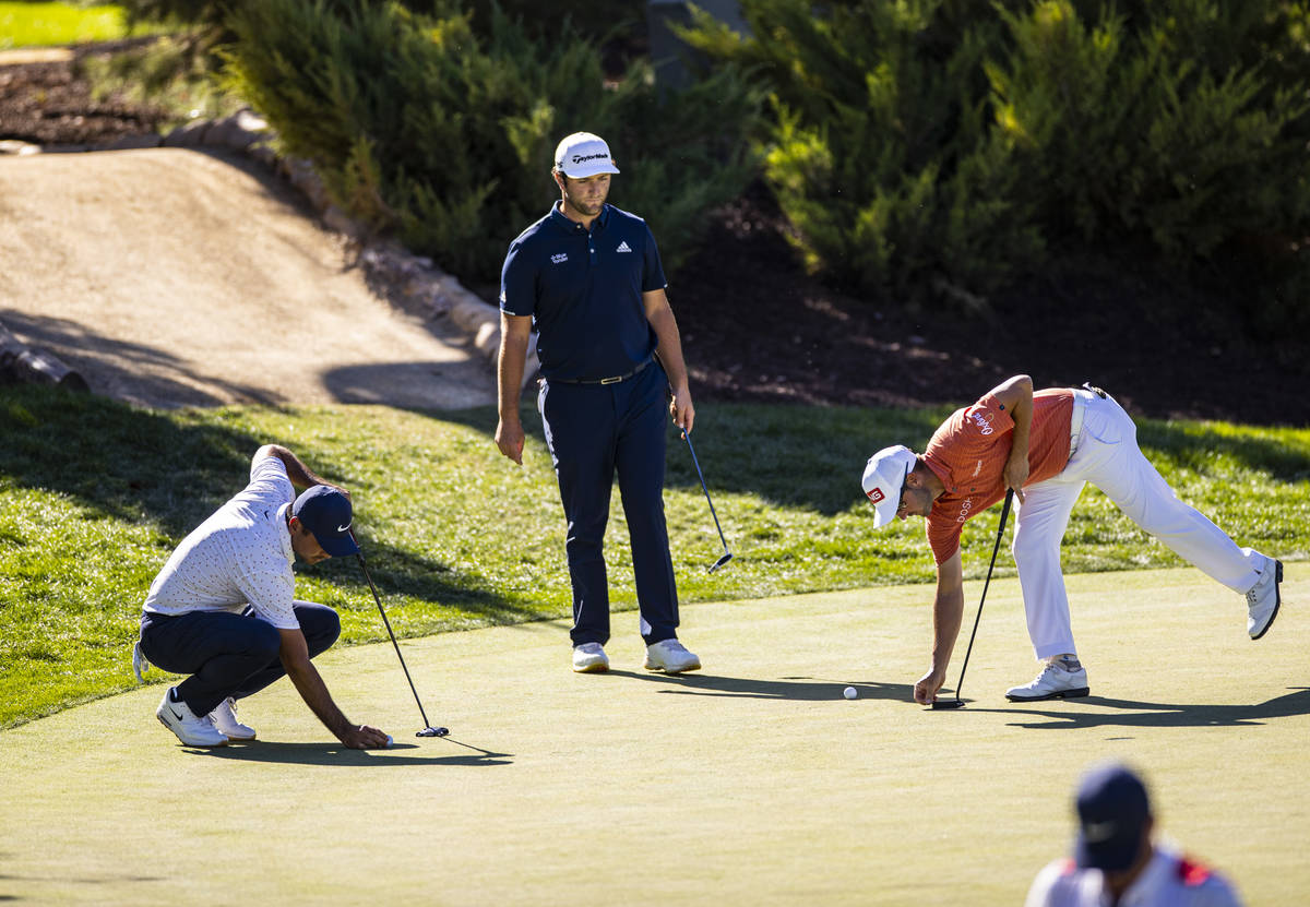 Jason Day, from left, Jon Rahm, and Andrew Landry prepare for putt shots at the 13th green duri ...
