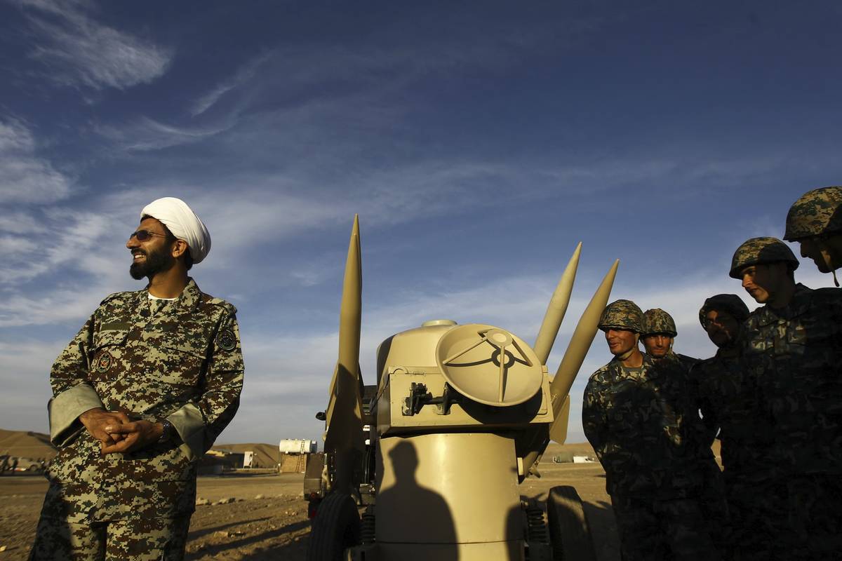 FILE - In this Nov. 13, 2012 file photo, an Iranian clergyman stands next to missiles and army ...