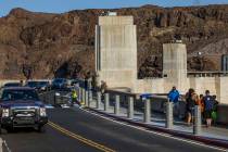 Visitors walk along the top of Hoover Dam, which reopened to the public after being closed for ...