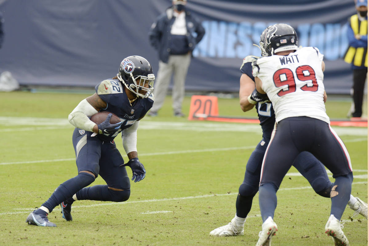 Tennessee Titans running back Derrick Henry (22) tries to get past Houston Texans defensive end ...